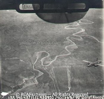 Aerial reconnaissance photograph of a river near Berat, Albania, with a B-25 visible in frame