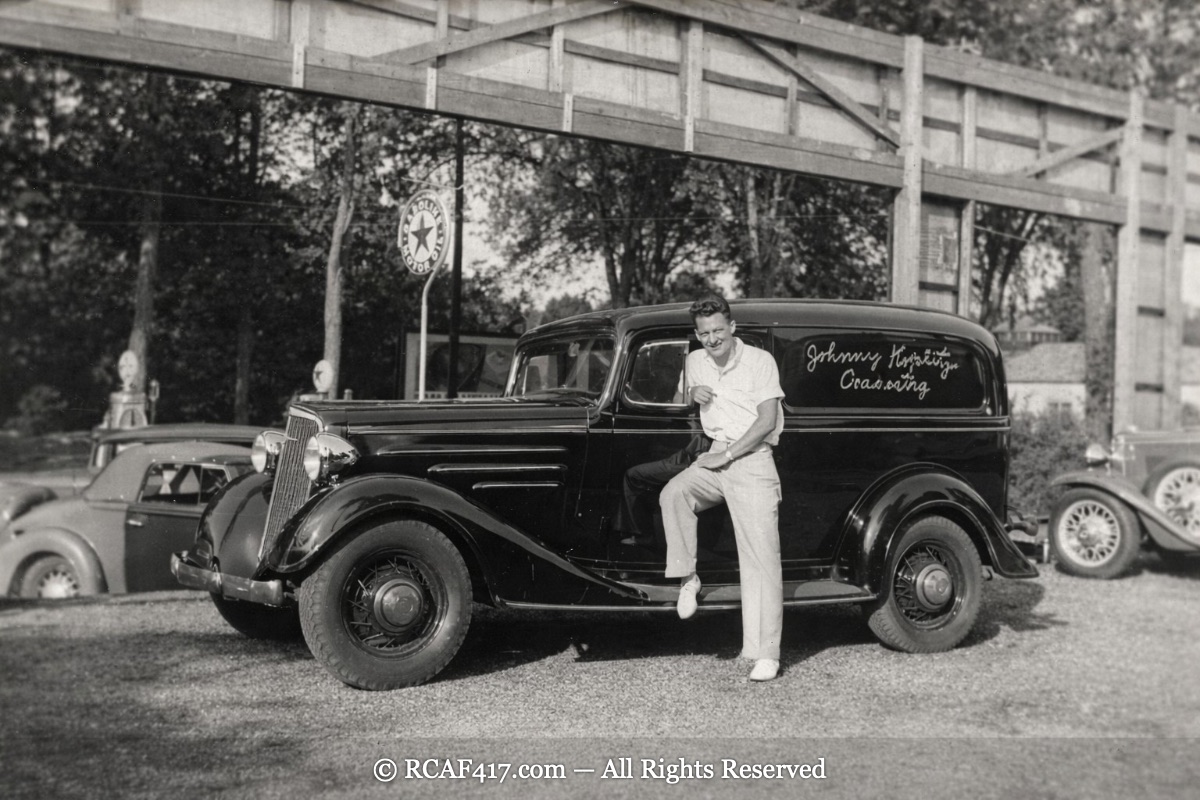 Koplitz leaning against the orchestra's own delivery truck, lettered 'Johnny Koplitz Orchestra' on the door